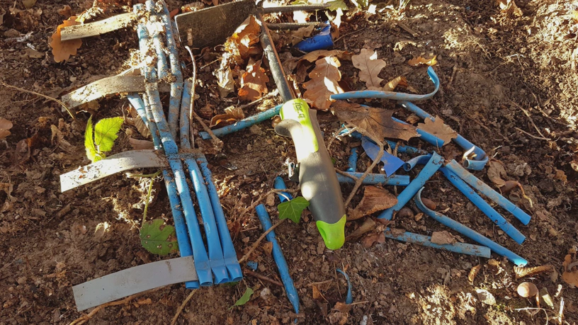 Viele kleine Rörchen aus Kunststoff, teilweise miteinander verklebt, auf dem Waldboden liegend.