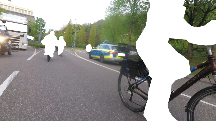 Hintenkamera. Links hinten steht der Lkw, davor der Radfahrer, der Polizist auf dem Motorrad fährt gerade los.